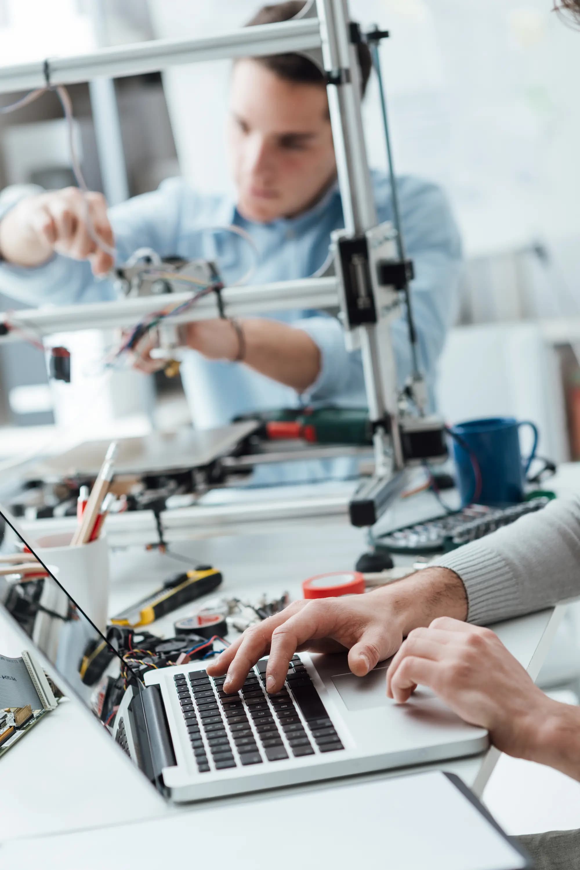 Engineers building and testing hardware and software in a modern software factory using CI/CD, DevOps, and automation for fast, reliable digital product delivery.