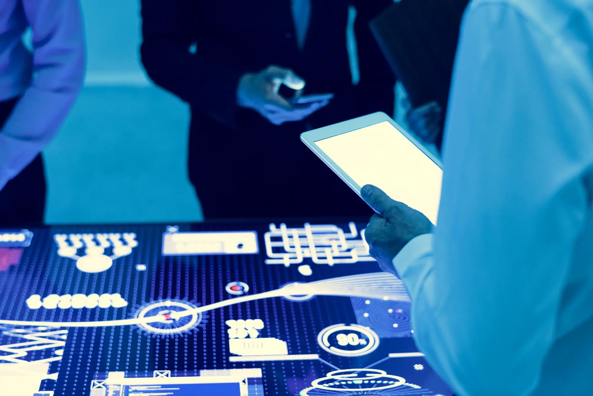 Business professionals analyzing real-time data integration dashboard on interactive digital table, illustrating API management, event-driven architecture, microservices, and modern enterprise system integration.