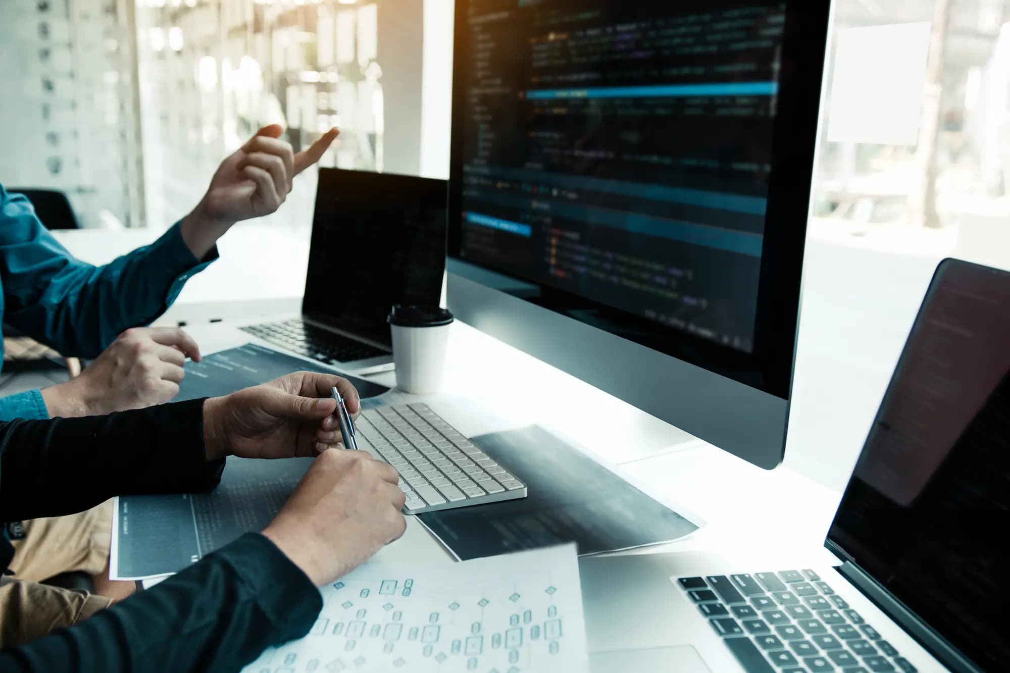 Developers reviewing API code and architecture on a large screen, illustrating API-first strategy, API design, governance, and modern software development.
